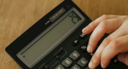 Photographie d'une main tape sur une calculatrice